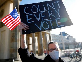 A member of the "Democrats Abroad" organization holds a placard in Berlin on Nov. 4, urging U.S. officials to count every vote before calling the current presidential election.