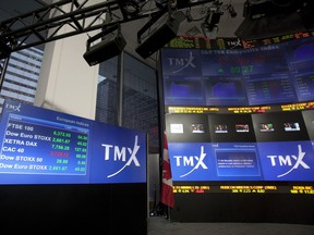 TMX Group Inc. signage and stock prices are displayed on a screen in the broadcast centre of the Toronto Stock Exchange.