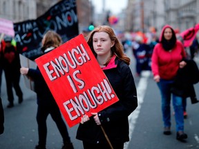 Climate activists hold placards as they march during a protest organized by the climate change action group Extinction Rebellion, in London, on February 22, 2020.