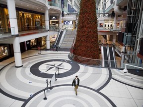 A shopper wearing a protective mask walks through a nearly empty Eaton Centre mall in Toronto, Ontario, Canada, on Monday, Nov. 23, 2020.