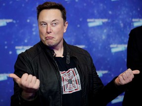 Tesla Inc CEO Elon Musk grimaces after arriving on the red carpet for the Axel Springer award, in Berlin on Dec. 1. His company debuts on the S&P 500 today.