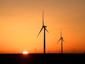 Wind turbines operate at sunrise in the Permian Basin oil and natural gas production area in Big Spring, Texas.