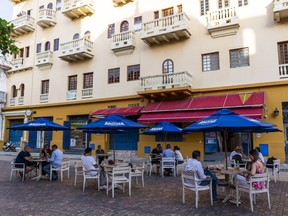 Customers dine on a restaurant patio in Colombia. COVID-19 took a heavy toll on Latin America with regional gross domestic product expected to contract by more than 7%.