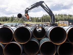 Pipe for the Trans Mountain pipeline being unloaded in Alberta, on June 18, 2019.