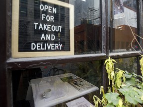 A sign for takeout and delivery inside a restaurant in Toronto.