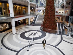 A shopper wearing a protective mask walks through a nearly empty Eaton Centre mall in Toronto, in November.