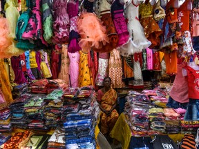 A vendor waits for customers at a clothes stall at a market ahead of Diwali, the Hindu festival of lights, in Chennai on November 13, 2020.