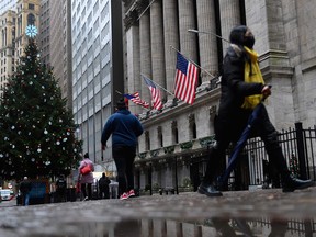 Pedestrians walk by the New York Stock Exchange.