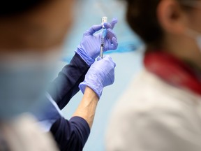 Technicians measure doses of the Pfizer vaccine for COVID-19 at the Virginia Hospital Center on Dec. 16, 2020 in Arlington, Virginia.