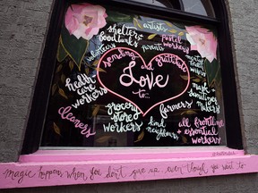 A sign in the window of a store offers support in Winnipeg.