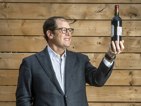 Adam Froman, founder and CEO of data collection and research technology company Delvinia Holdings Inc., holding a bottle of wine.