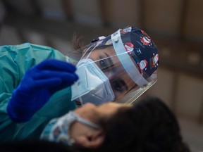 A healthcare worker conducts an antigen rapid test for COVID-19 during a mass coronavirus screening in Tui, northwestern Spain, on December 8, 2020.