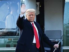 Outgoing U.S. President Donald Trump waves as he departs the White House on Wednesday on a Marine One. He did not attend the inauguration for President Joe Biden.