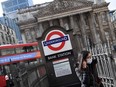 A woman wearing a protective face mask walks out of an underground tube station in the City of London financial district. The poll's findings underscore concerns that the pandemic and the U.K.'s departure from the European Union may make it less attractive to workers mobile enough to move.