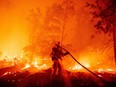 A firefighter douses flames as they push towards homes during the Creek fire in the Cascadel Woods area of unincorporated Madera County, California on September 7, 2020.