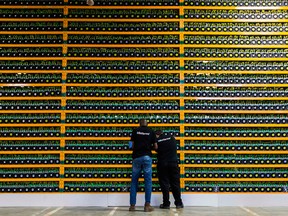 Two technicians inspect Bitcon mining at Bitfarms in Saint Hyacinthe, Quebec, in 2018.