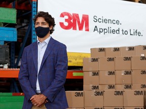 Prime Minister Justin Trudeau listens to Ontario Premier Doug Ford during a visit at 3M's plant in Brockville, Ont., on August 21, 2020.