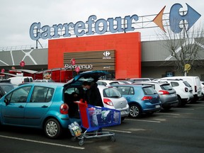 A customer empties his cart in front of a Carrefour hypermarket store in Carquefou near Nantes, France January 13, 2021.