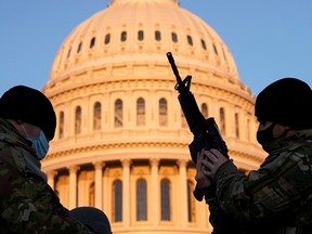 A member of the National Guard is given a weapon before Democrats begin debating one article of impeachment against U.S. President Donald Trump at the U.S. Capitol, in Washington, U.S., Jan. 13, 2021.
