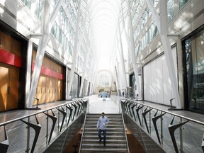 A pedestrian walks down stairs at Brookfield Place in the financial district of Toronto, on Friday, May 22, 2020.