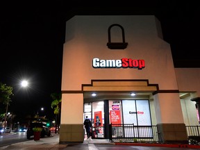 A man steps out of a GameStop store in Alhambra, California on January 27, 2021. An epic battle is unfolding on Wall Street, with a cast of characters clashing over the fate of GameStop, a struggling chain of video game retail stores.