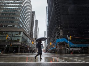 A lone pedestrian crosses Yonge Street in downtown Toronto. cCommercial REITs were thrown into uncertainty as the COVID-19 pandemic undermined fundamental assumptions about the way Canadians will work and shop in the future.