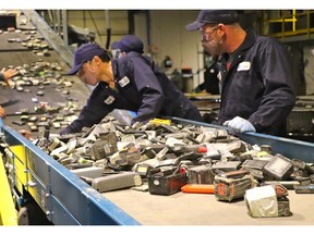 Li-Cycle employees feed lithium-ion batteries into the shredder at Kingston, ON facility