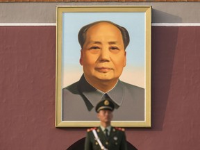 A member of the Chinese People's Liberation Army stands guard in front of a portrait of former Chinese leader Mao Zedong at Tiananmen Square in Beijing, China on Monday, Oct 16, 2017.