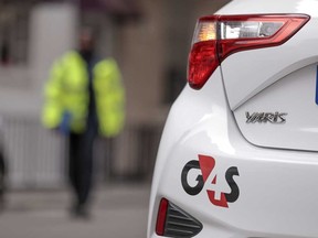 A G4S Plc logo sits on an automobile outside one of the company's offices in London, U.K. Allied Universal won the auction for the security company with a $5.3 billion bid.