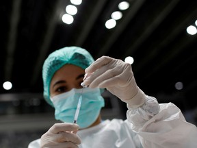 A health-care worker prepares a dose of Sinovac's vaccine for the coronavirus disease (COVID-19) during a mass vaccination for medical workers at the Istora Senayan stadium in Jakarta, Indonesia, February 4, 2021.