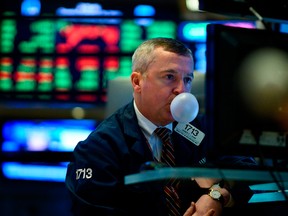 A trader makes a bubble with a chewing gum ahead of the closing bell on the floor of the New York Stock Exchange.