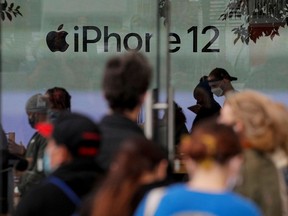 Customers wait in line outside an Apple Store to pick up Apple's new 5G iPhone 12 in Brooklyn, New York, Oct. 23, 2020.