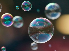 Soap bubbles floating in the air on a dark background.