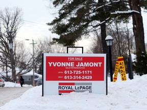 A home for sale sign half buried in the snow in Ottawa.