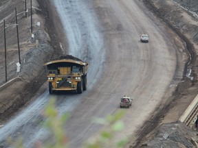 A heavy hauler drives past smaller trucks near the entrance of Suncor Energy's North Steepbank Mine.