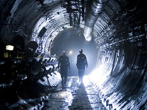 Two miners silhouetted in a uranium mine.