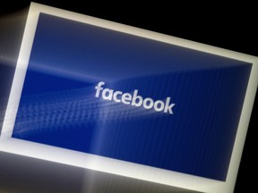 A Facebook App logo displayed on a smartphone. "Facebook" is written in white letters against a blue background.