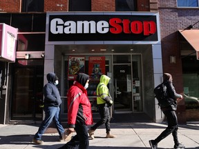 People walk by a GameStop store in Brooklyn.