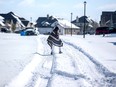 A man walks to his friend's home in a neighbourhood without electricity as snow covers the road in Pflugerville, Texas, Feb. 15, 2021.
