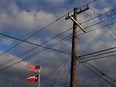 The U.S. and Texas flags fly next to a power pole in Houston, Texas.