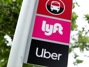 A sign with a bus logo, a Lyft logo and an Uber logo.