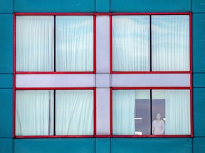 A person looks out the window of a quarantine hotel in Toronto.