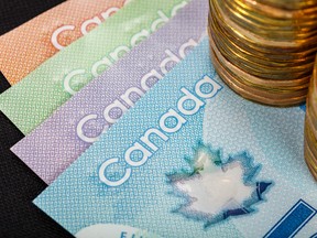 Canadian banknotes with stacks of loonies.