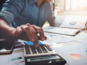 Business accounting concept, Business man using calculator with computer laptop, budget and loan paper in office.