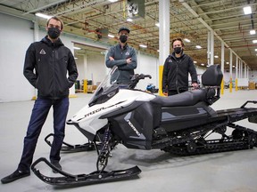 Taiga CEO Sam Bruneau, right, chief engineer Paul Achard, centre, and Gabriel Bernatchez, chief technical officer, with their Nomad snowmobile in the company's production facility in the LaSalle borough of Montreal.