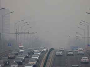 Cars move on a road during a day with polluted air in Beijing, China, February 13, 2021.