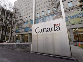 A Government of Canada sign sits in front of a Library and Archives Canada building next to Parliament Hill in Ottawa.