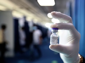 A health worker holds a vial of Pfizer-BioNTech vaccine against the coronavirus at a vaccination centre set up at the Dubai International Financial Center in the Gulf emirate of Dubai, on February 3, 2021.