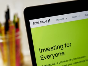 he website home screen for Robinhood is displayed on a laptop computer with a jar of pencils and pens in the background.