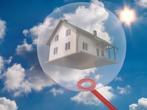 A house in a bubble on a background of blue sky and fluffy clouds.